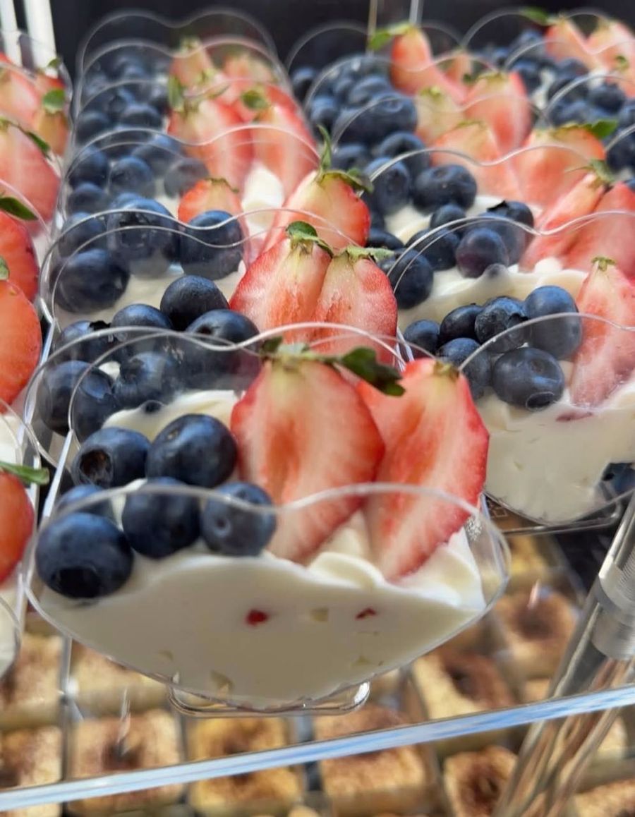 Dessert cups topped with strawberries and blueberries