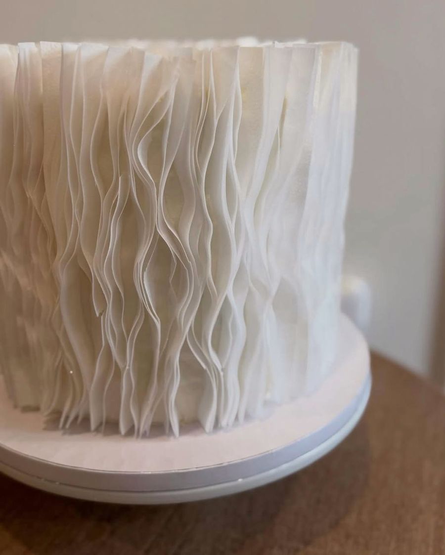 Tall white cake with textured buttercream ruffles
